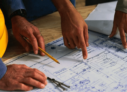 Hands reviewing construction diagram.